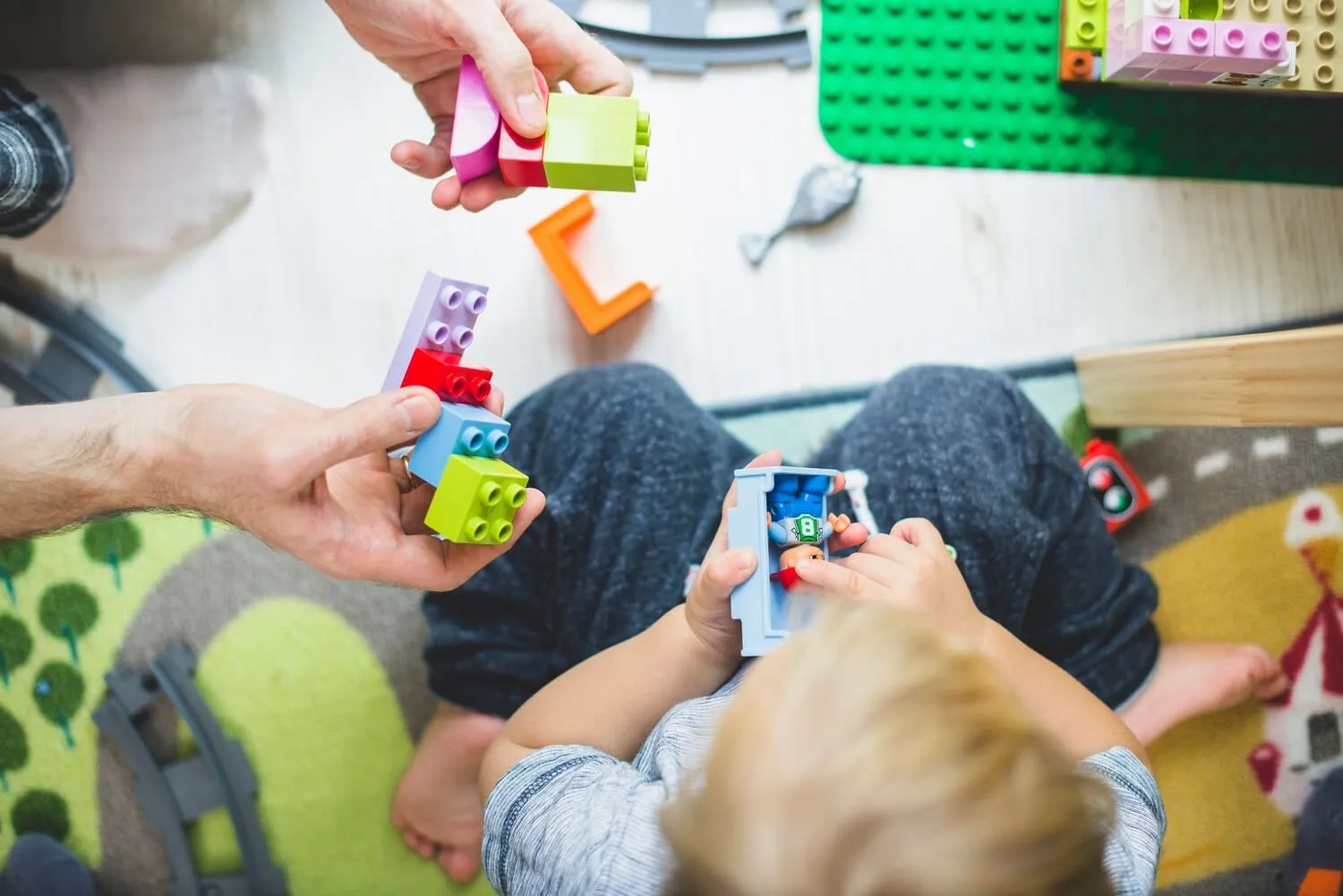 A caregiver helping a child with a shape-sorting toy