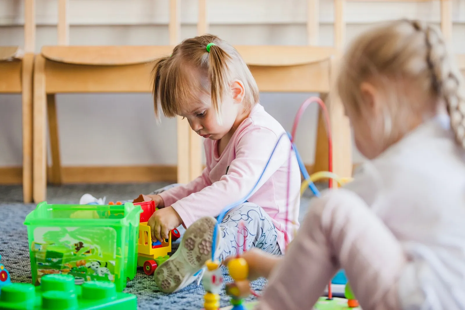 A young child exploring toys in a playroom